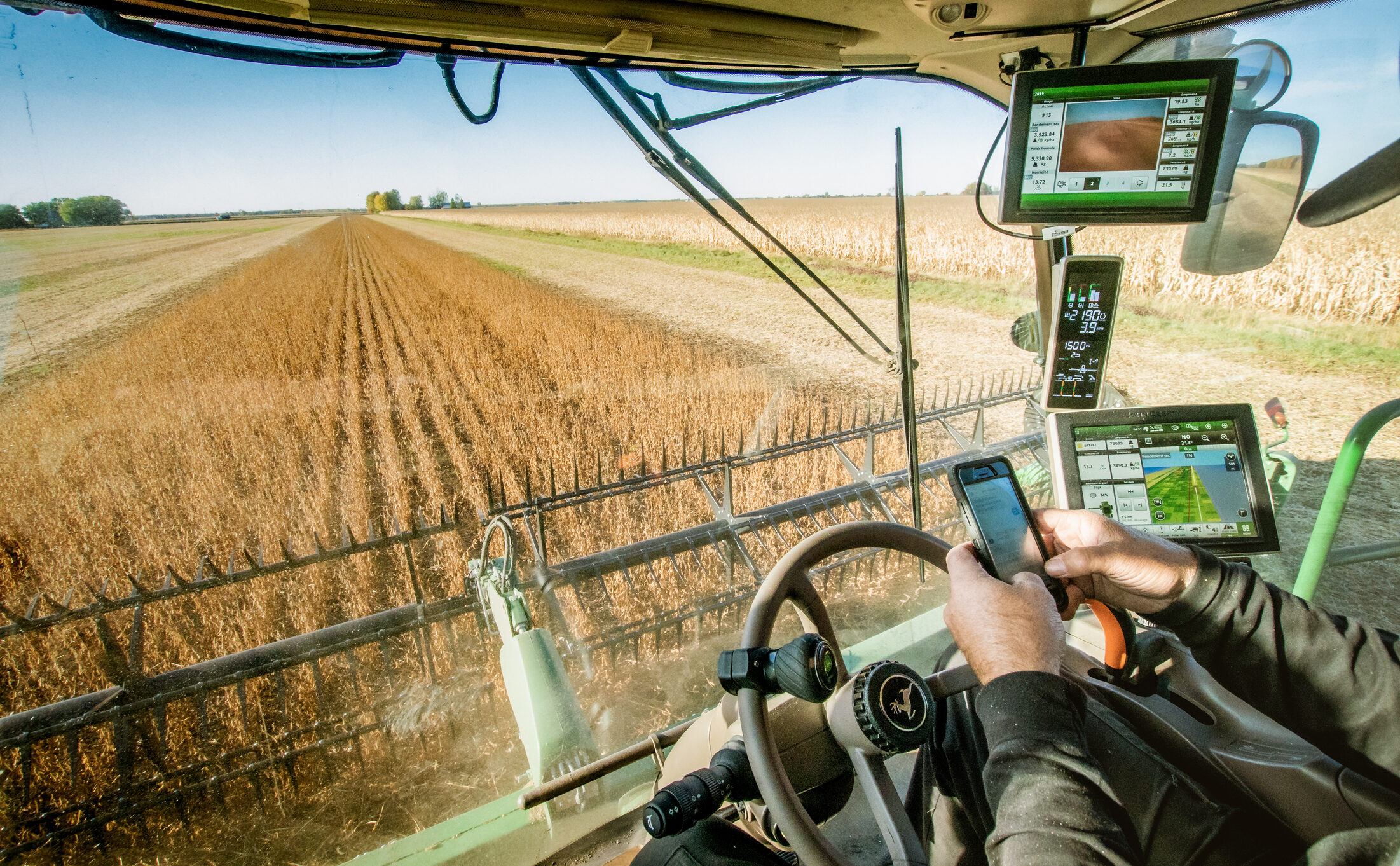 FieldDeck open on a phone inside a combine cab during harvest